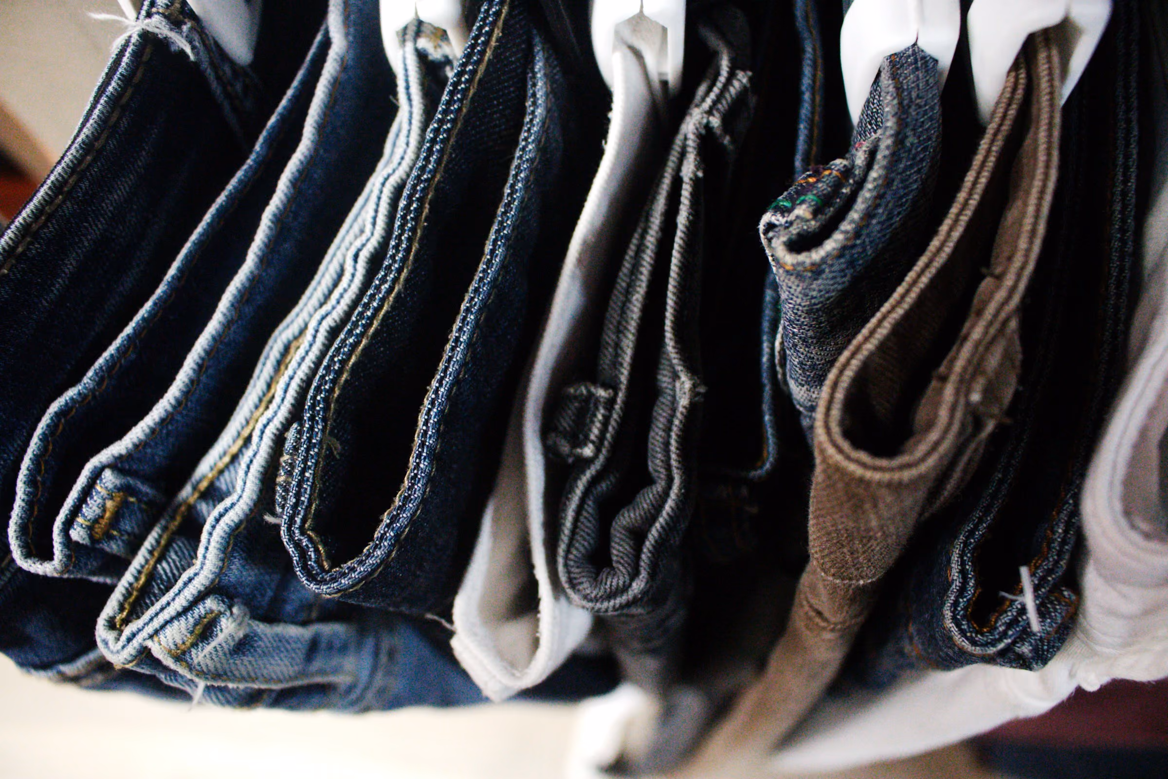 Hemmed jeans and pants hanging after alterations